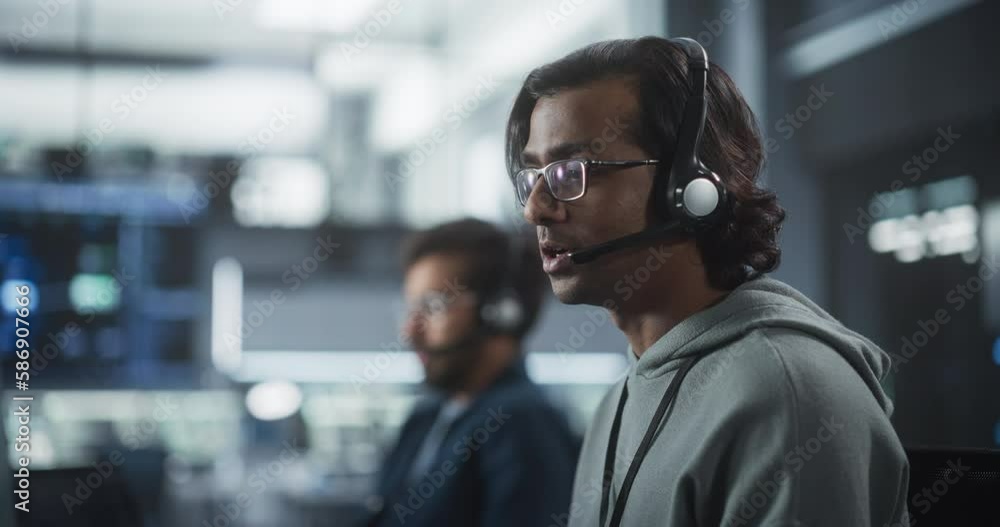 Fototapete Portrait of a Help Desk Specialist Having a Conversation on a Call, Providing Technical Support to Client Experiencing Software Issues. Indian Man Using a Headset to Talk with a Tech Team