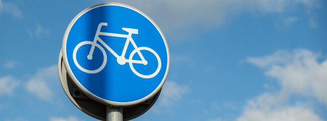 Round road sign depicting white bicycle on blue background, meaning mandatory bike path for...