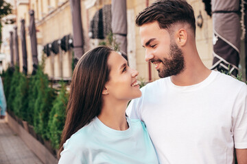 Obraz premium Smiling beautiful woman and her handsome boyfriend. Woman in casual summer jeans clothes. Happy cheerful family. Female having fun. Sexy couple posing in the street at sunny day