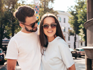 Smiling beautiful woman and her handsome boyfriend. Woman in casual summer jeans clothes. Happy cheerful family. Female having fun. Sexy couple posing in the street at sunny day. In sunglasses