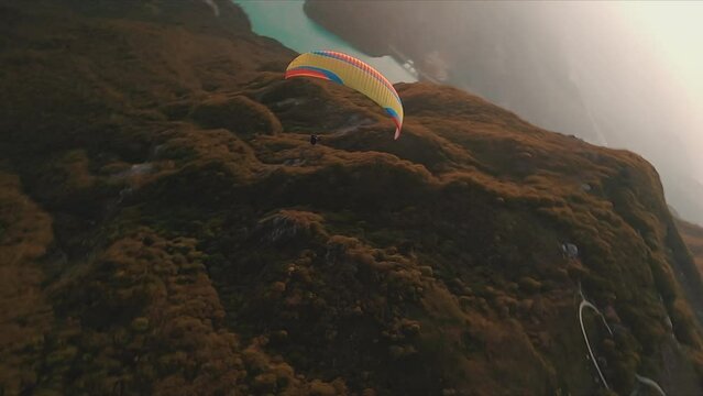 extreme fpv of a paraglider  over the mountain