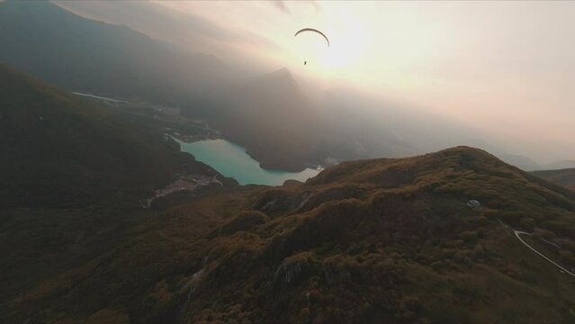 silhouette of a paraglider over the mountains