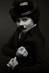 black and white portrait of a girl in the image of an English silent movie comedian on a black background