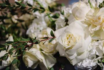 Delicate white roses flowers. Composition with copy space. Soft blurred flowers with soft bokeh in pastel tone for background. Closeup decor. Banner. Detail of decor in the interior on table.
