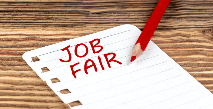 Word JOB FAIR on a paper with ped pencil on wooden background