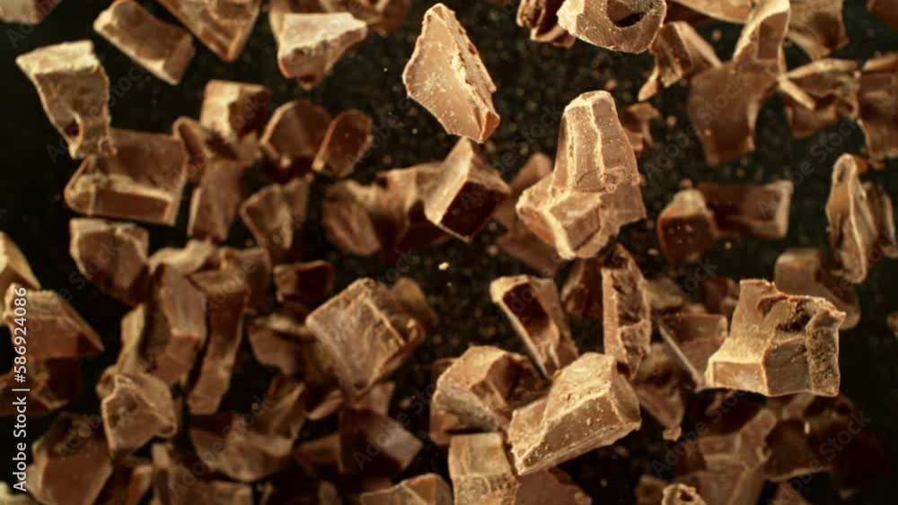 Poster super slow motion of rotating group of raw chocolate pieces. super fast camera motion. filmed on hig