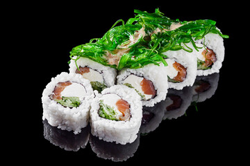 sushi roll with tuna cucumber cream cheese and chuka on a black mirror background