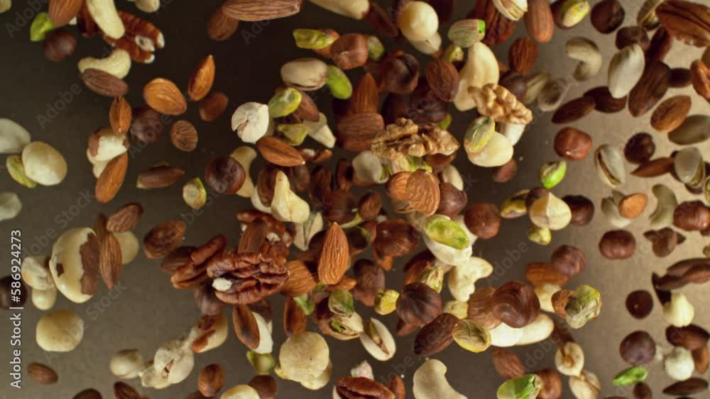Poster super slow motion of rotating mix nuts up to the air. filmed on high speed cinema camera, 1000fps, p