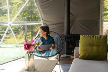 childhood, technology and hygge concept - happy little girl with tablet pc computer in geo dome tents