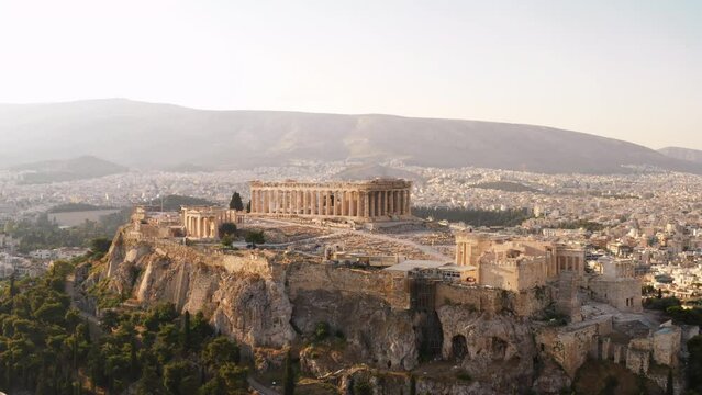 Greece Acropolis city of Athens parthenon symbol of ancient aerial view slide from drone on panorama of residential buildings at sunset summer. Lights sun, lens flare. World Heritage sites. History