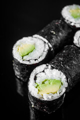 maki sushi roll with avocado on a black mirror background