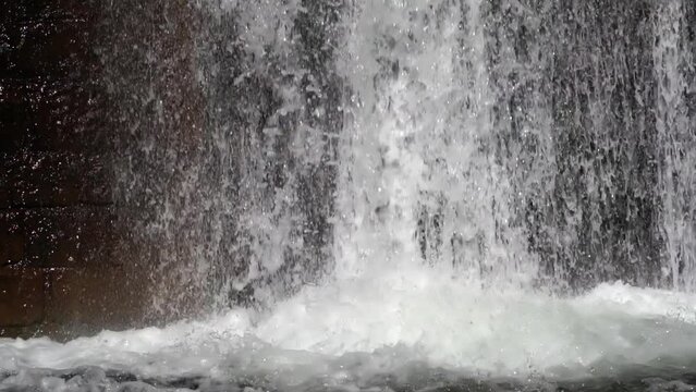 Water flowing into a water storage reservoir during autumn heavy rains, flood pervention, slow motion, closeup