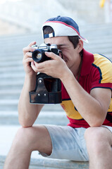 Tourist man with retro photo camera, student photographer. Trip, tourism