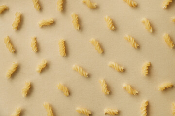 Top view of spiral pasta pattern. Raw pasta on neutral background, flat lay. Wheat food concept.