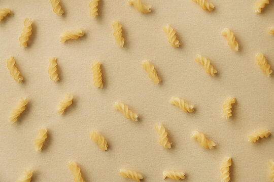 Top view of spiral pasta pattern. Raw pasta on neutral background, flat lay. Wheat food concept.