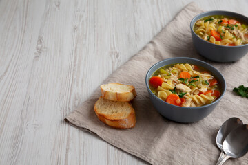 Homemade Chicken Noodle Soup in a Bowl, side view. Space for text.