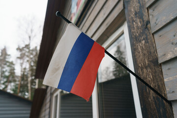 Photography of the national flag of the Russian Federation hanging on the building.  Tricolor. Red, Blue, White stripes. Politics concept. Close up photography.
