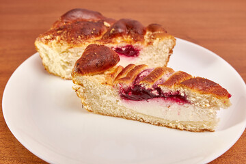 Delicious pie with cheese and cherry jam on a white plate.