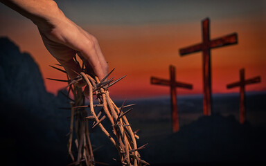 Hand holding crown of thorns andThree Crosses On Calvary Hill - 586936099
