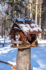 bird feeder made of natural materials is set in a winter snowy forest