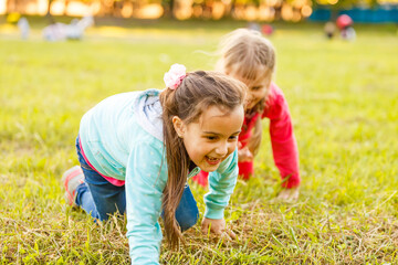 Adorable little girls having fun playing outdoors on summer day