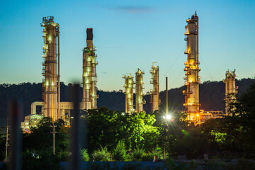 Fototapeta premium Twilight scene of tank oil refinery plant and tower column of Petrochemistry