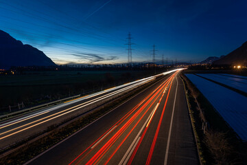 Fototapeta na wymiar Vue des phares en filé sur l'autoroute le soir à 18h30 en direction du Valais en Suisse