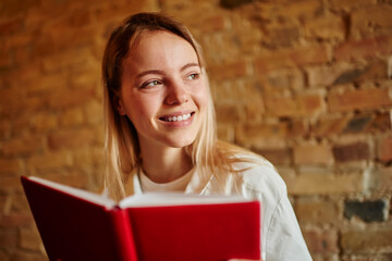 Happy woman looking away while reading book in cafe