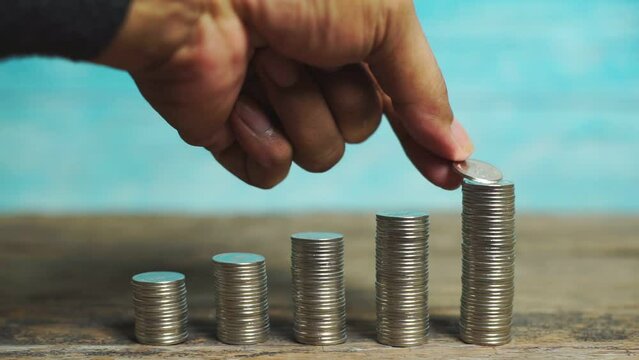 4K. Save money and account banking for finance concept, Hand with coin and piggy bank on blurred background