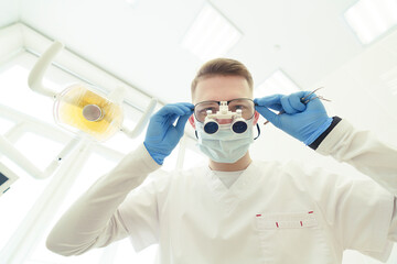 dentist bends over the patient and is about to begin the examination