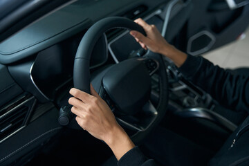 Naklejka premium Hands of a young woman lie on the steering wheel
