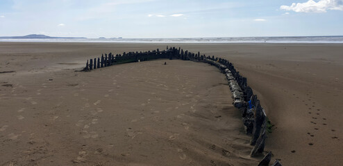 A shipwreck on a welsh beach with a view of the ocean and coastline