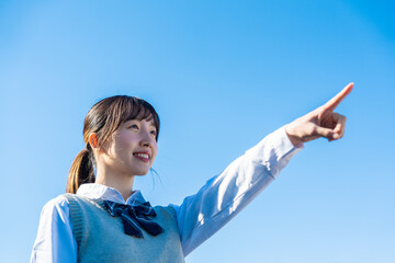 制服で上を指差す女子高生