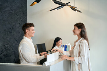 Smiling lady shopping via NFC in beauty salon