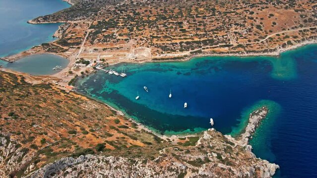 View from above, aerial view of a transparent and turquoise sea with some boats and yachts. Mediterranean sea coast, Knidos Ancient city, Datca, Turkey. Summertime vacation and travel to seaside