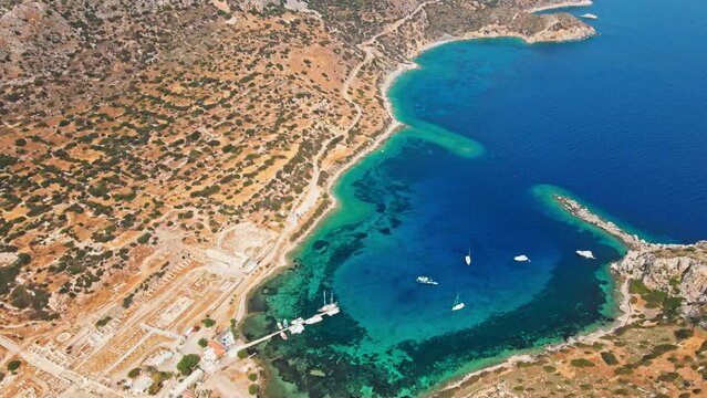 View from above, aerial view of a transparent and turquoise sea with some boats and yachts. Mediterranean sea coast, Knidos Ancient city, Datca, Turkey. Summertime vacation and travel to seaside