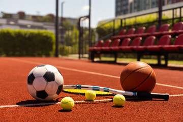 A group of sports equipment on black background including tennis, basketball, and soccer and boxing equipment on a background with copy space