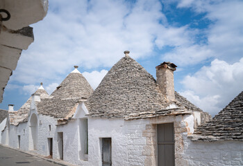 Fototapeta na wymiar Beautiful street in the center of the village of Alberobello with trulli scattered everywhere
