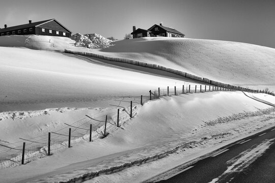 Winterruhe auf der Alm - Stimmungsvolles  Landschaftsbild mit Häusern im Morgenlicht - Schwarz Weiß Foto