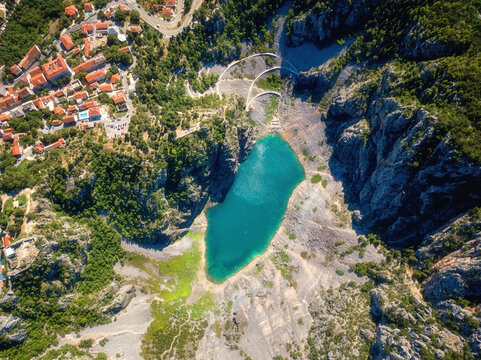 Scenic aerial view of Imotski Blue Lake (Modro jezero) in limestone crater, Dalmatia, Croatia. Nature summer landscape, popular tourist attraction, outdoor travel background