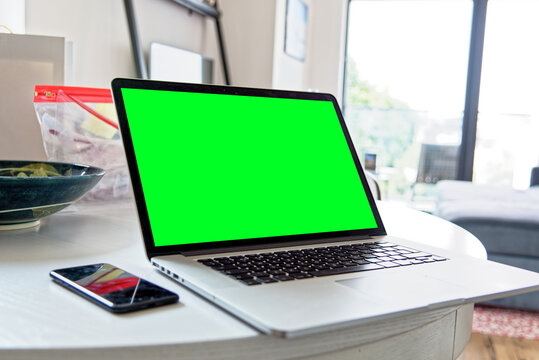 Young professional man using a laptop with a green screen