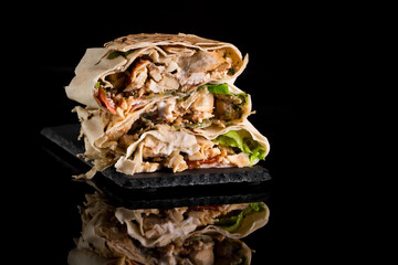 shawarma in size on a gray board on a black mirror background close-up
