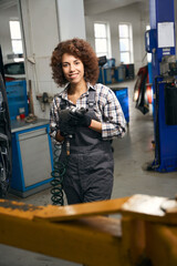 Smiling multiracial woman holding an air screwdriver in her hands