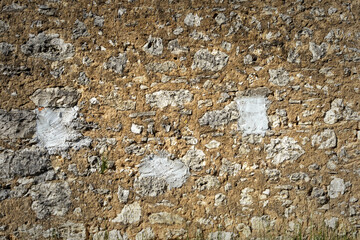old stone wall textured with rough stone and sand cement filler