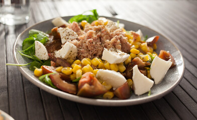 Fish salad with canned tuna and corn, tomatoes and arugula