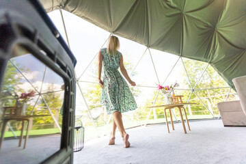 woman inside a geodesic glamping tent