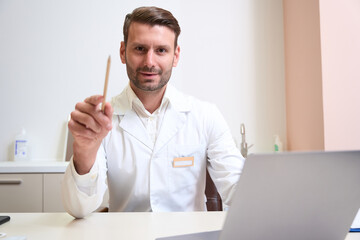Fototapeta premium Handsome doctor in uniform is posing at the photo camera