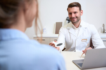 Fototapeta premium Handsome Caucasian ophthalmologist is getting consultation in his clinic