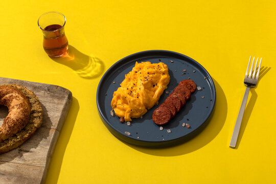Turkish breakfast. Scramble eggs and fried sausage. "Semit" with olive pate. Tea in glass. 