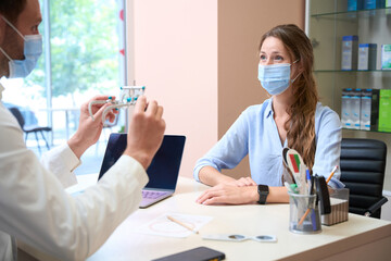 Beautiful lady in protective mask is visiting ophthalmology clinic